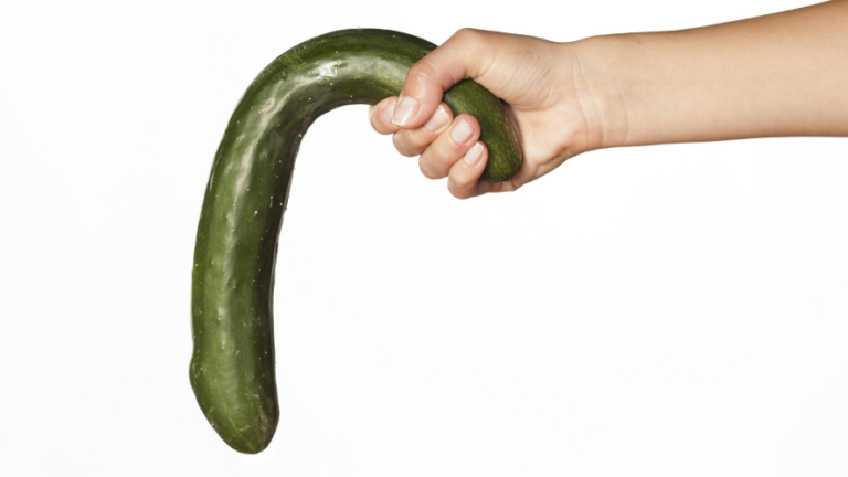 Hand holding a bent cucumber