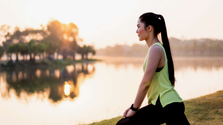 Woman doing yoga on the grass by the river