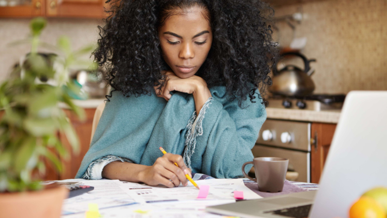 Woman sitting at table filling in papers and managing finances