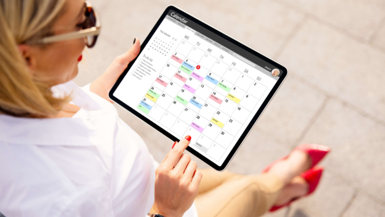 Woman using calendar app on tablet device while standing outdoors