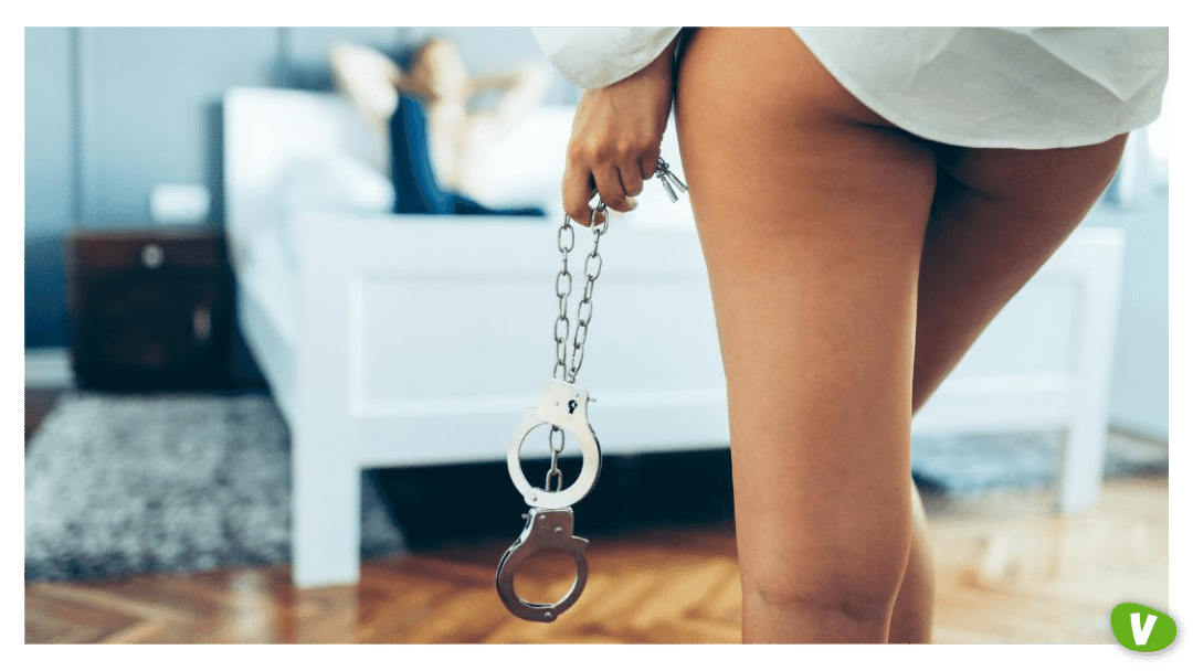 woman holding sex toy handcuffs for sexual dominance