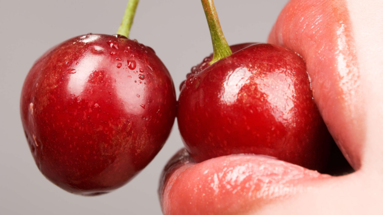 Woman with cherries in her mouth