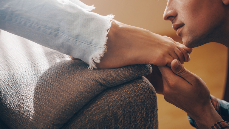 man holding a woman's foot
