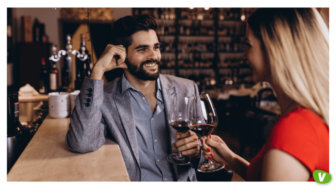 Attractive young couple clinking by wine glasses in restaurant during date