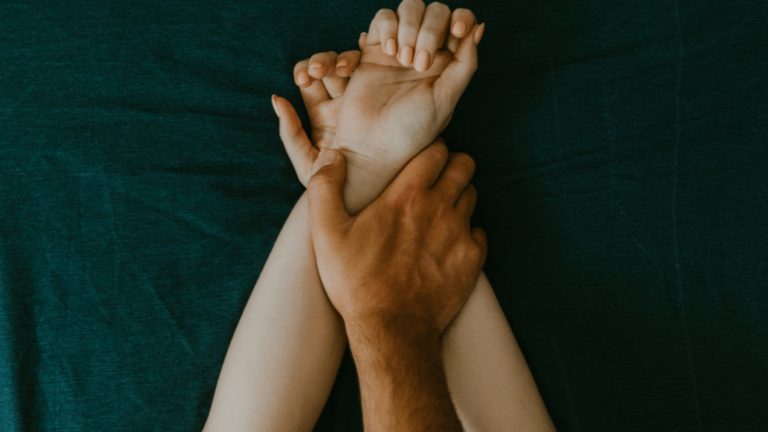 man and woman hands having sex on a bed. make love and grabbing each other's hands