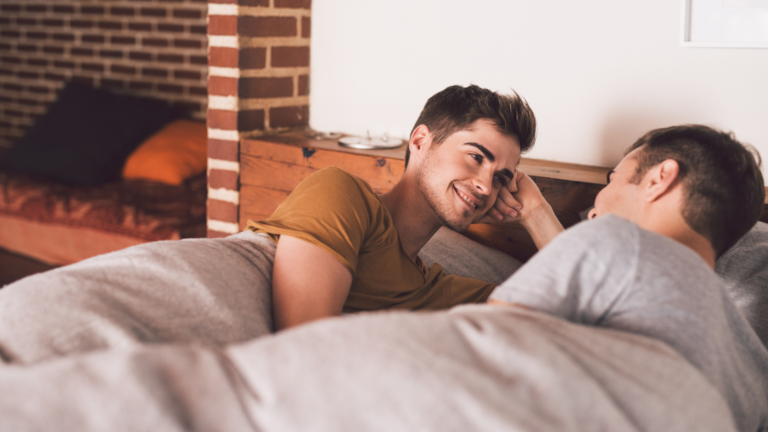 gay couple talking in bed