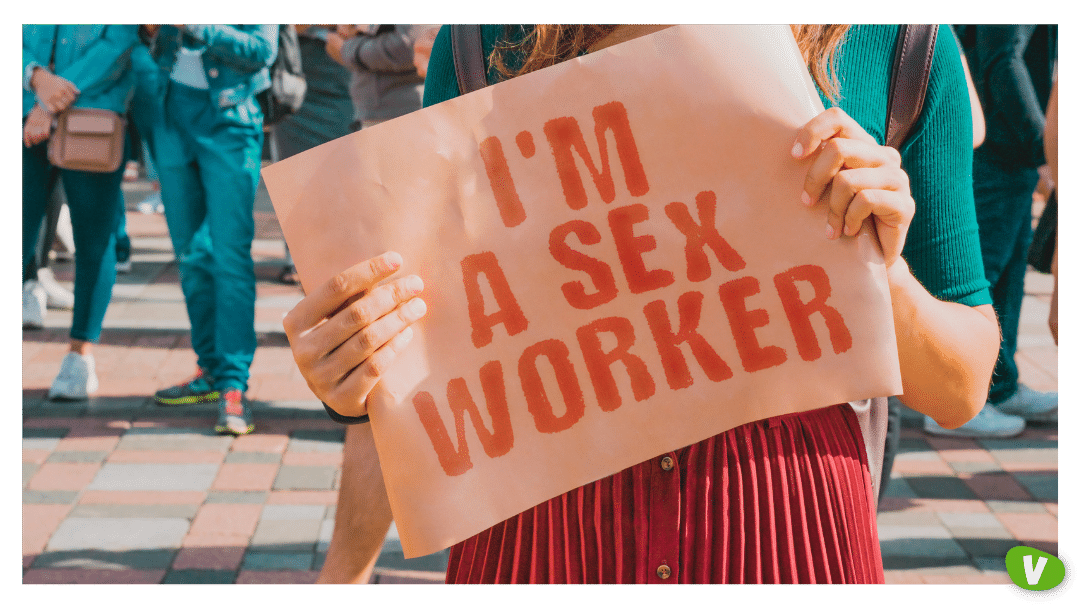 the phrase " I'm a sex worker " on a banner in women's hand