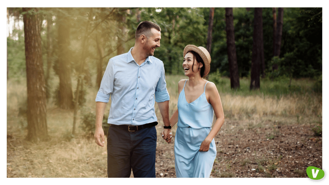 couple walking through the woods on a summer evening