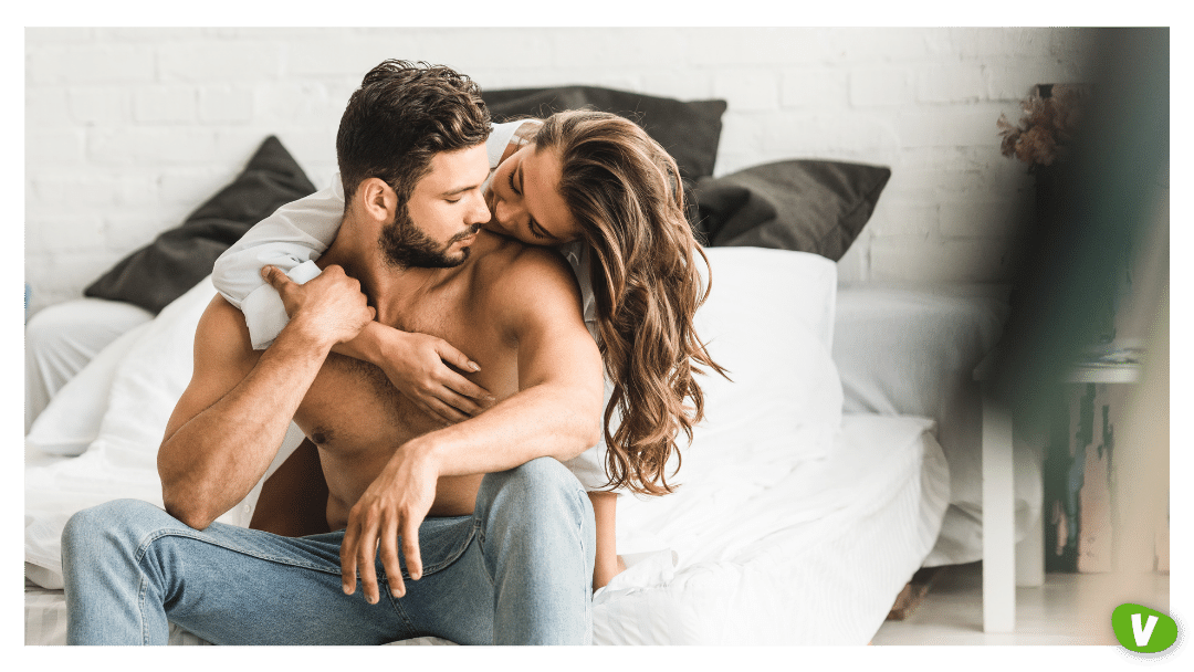 two people hugging while sitting on the bed