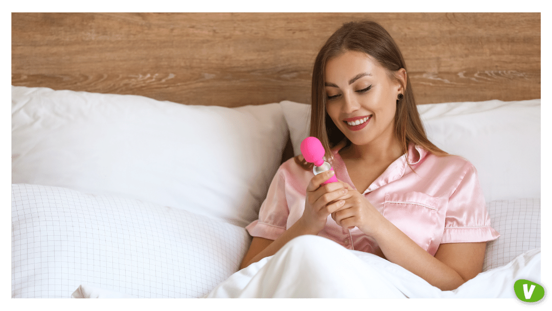 woman in bed holding a vibrator