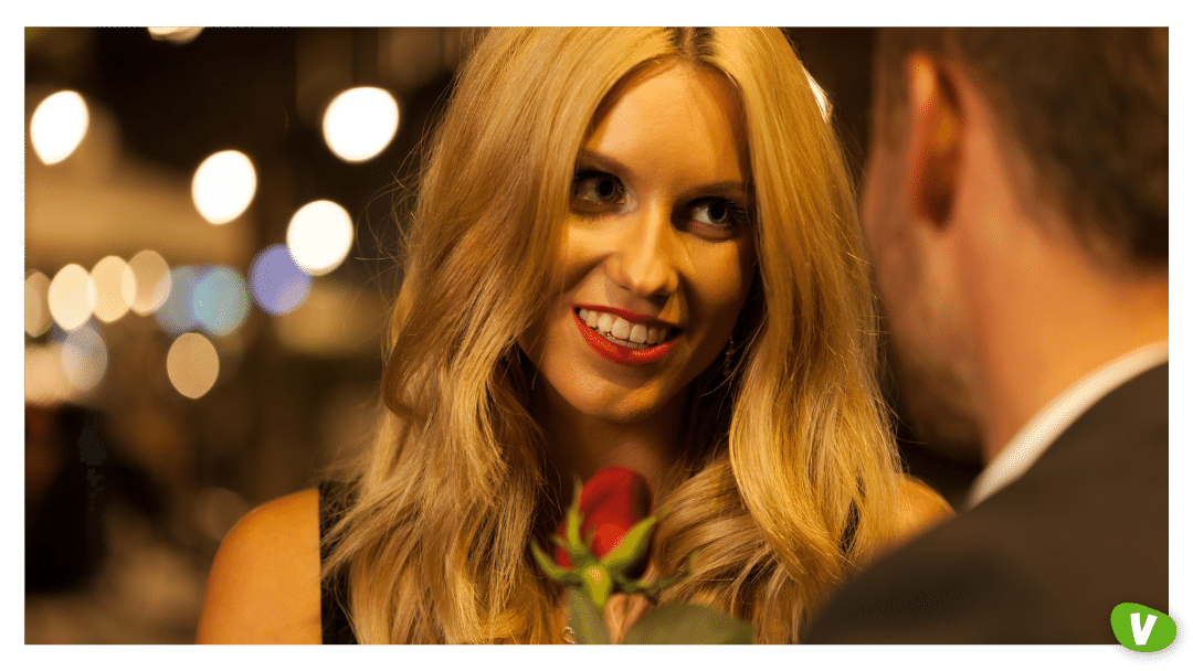 close up of a man and a woman on a date with the woman holding a rose