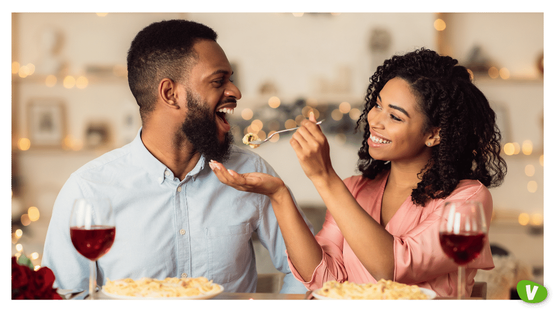 couple on a date with woman feeding her partner pasta