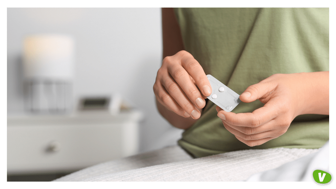 a woman holding a blister pack of emergency contraception pills