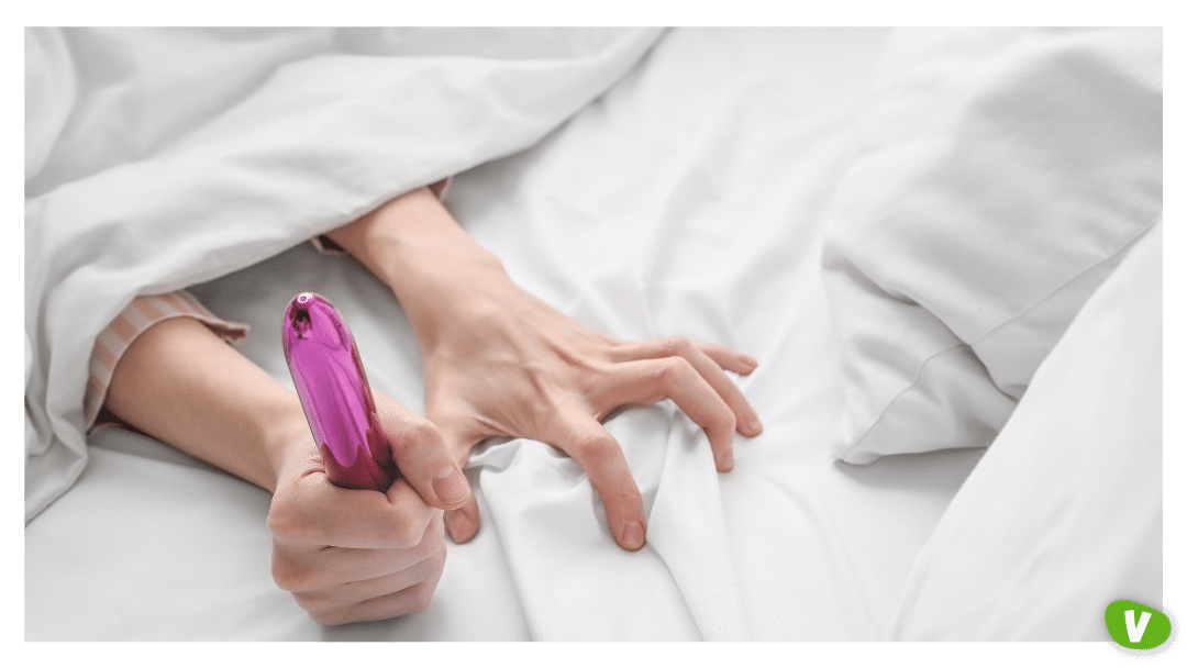 a photo of hand under the duvet holding a vibrator