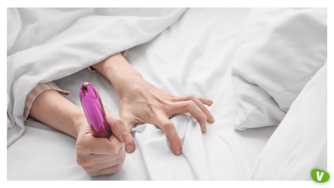 a photo of hand under the duvet holding a vibrator