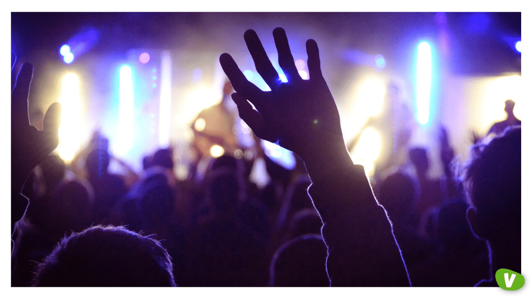 band members in yellow lights with audience cheering