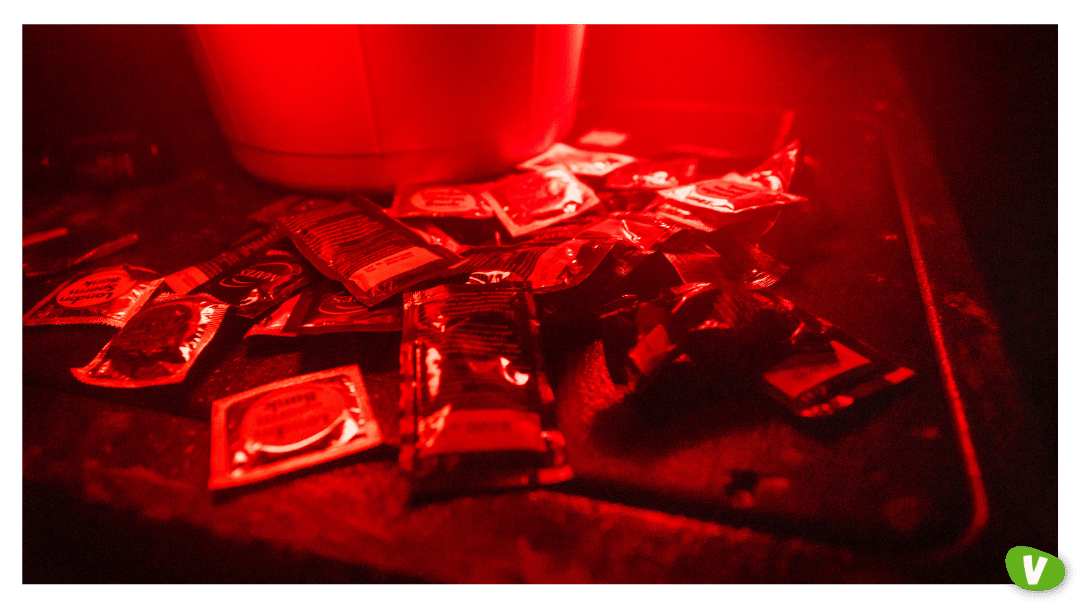 close up of condoms in a red lights at a sex party