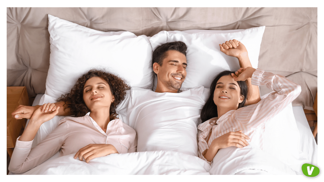 Man with Two Beautiful Women in Bed. Polyamory Concept