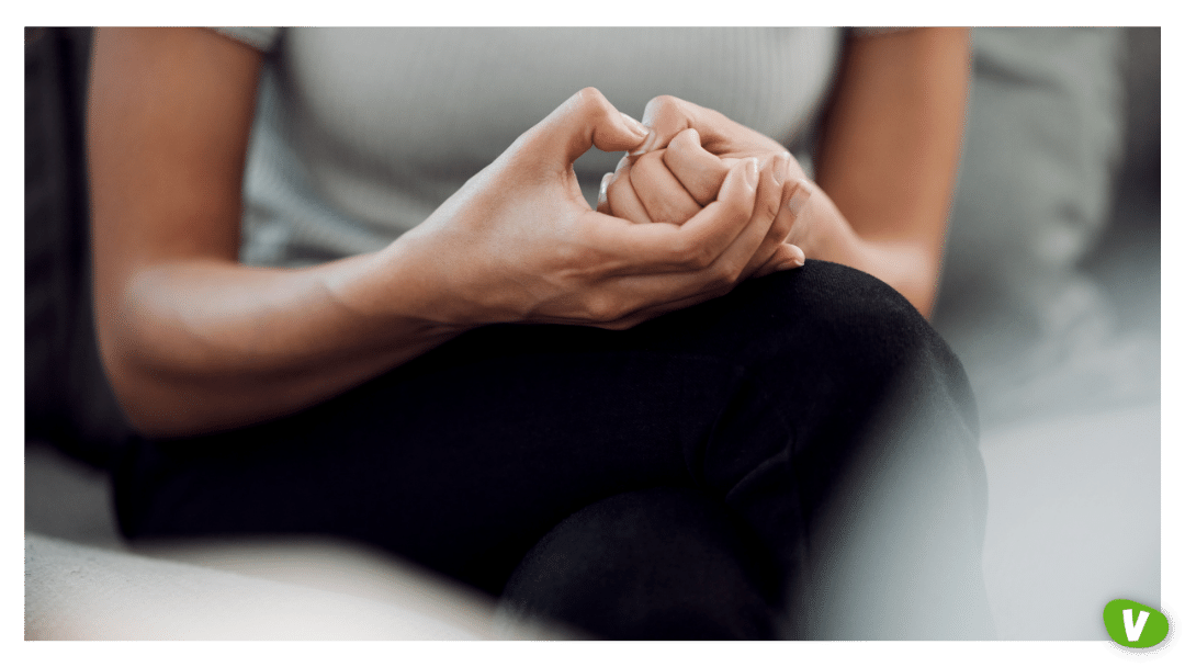 cropped shot of a woman sitting and picking her hands anxiety concept