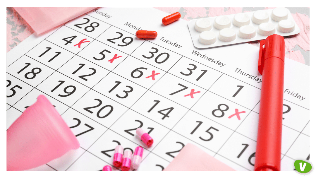 Menstrual Calendar with Feminine Products and Pills on Color Background