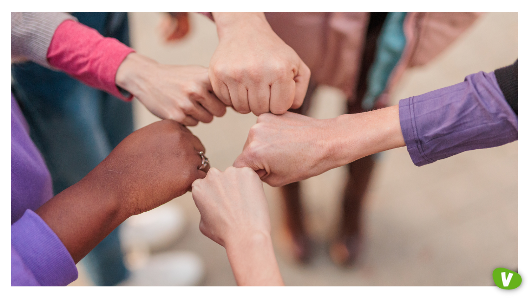 Close-up of a diverse group of people forming a supportive circle with fist bumps, symbolising unity and solidarity, feminism and sex work
