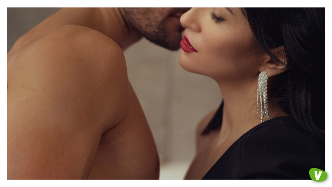 A close-up of a shirtless man and a woman leaning in for an intimate kiss, representing the mix of passion and post-orgasm guilt that can contribute to post sex anxiety and anxiety after seeing an escort.
