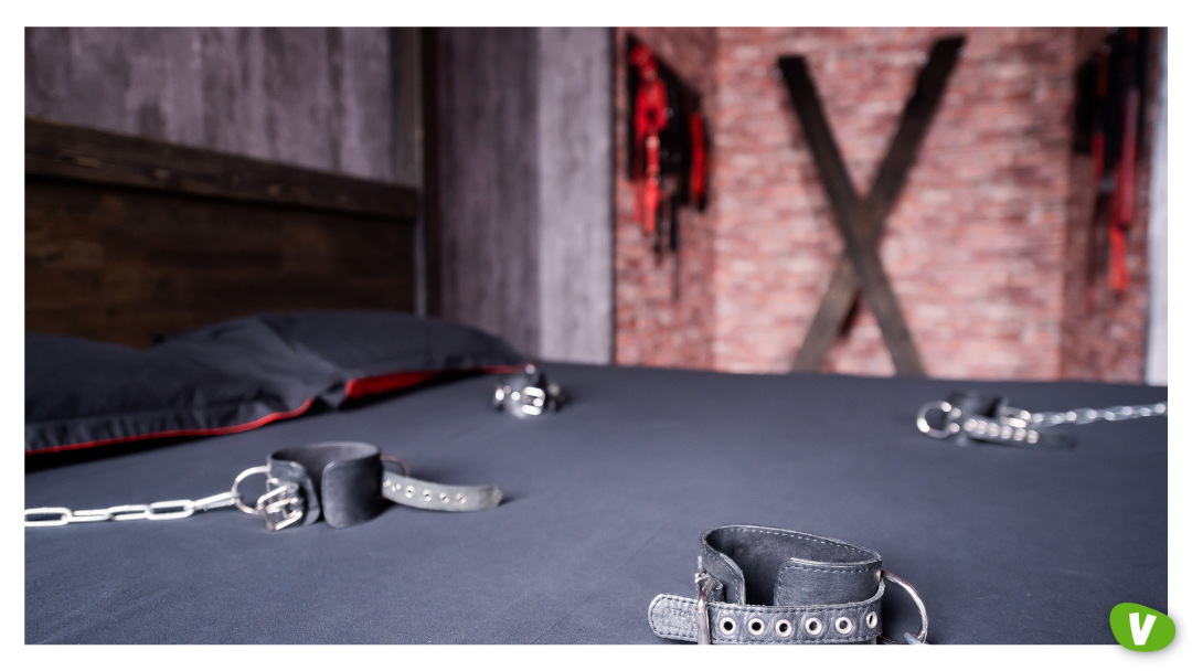 Bedroom scene with cuffs and restraints prepared for safe kink exploration and taboo fantasies roleplay with an escort in a respectful, consensual setting.