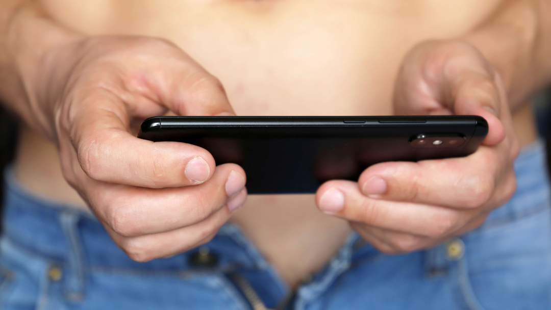 Man sitting down holding mobile phone